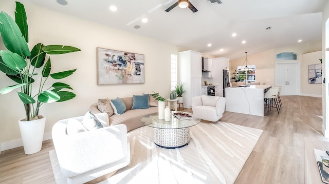 living room featuring light wood-type flooring, lofted ceiling, and ceiling fan