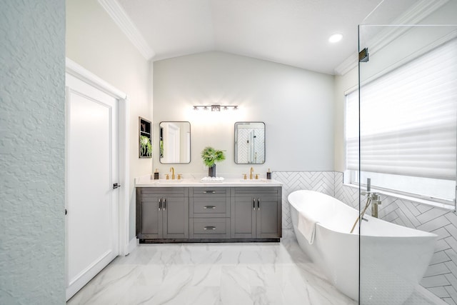 bathroom featuring tile walls, a washtub, lofted ceiling, crown molding, and vanity