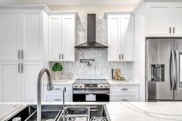 kitchen featuring wall chimney exhaust hood, stainless steel appliances, and white cabinets