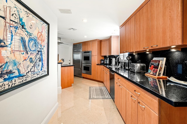 kitchen featuring dark stone countertops, appliances with stainless steel finishes, sink, and tasteful backsplash