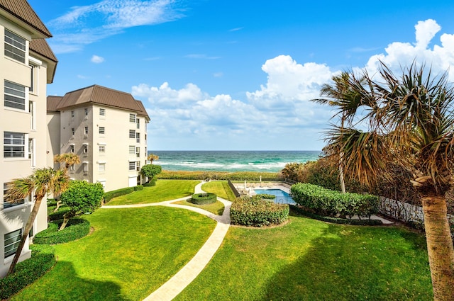 view of yard with a water view and a beach view