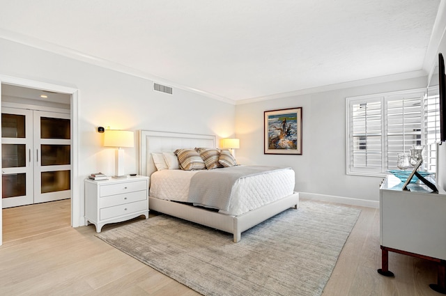 bedroom featuring light wood-type flooring and ornamental molding