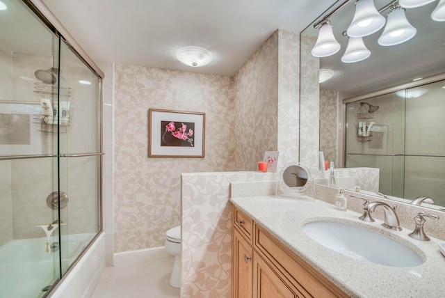 full bathroom with tile patterned floors, combined bath / shower with glass door, vanity, and toilet