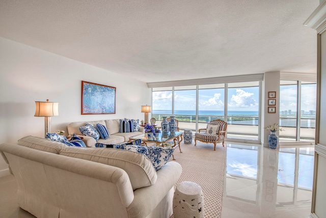 living room featuring a textured ceiling, a water view, and expansive windows