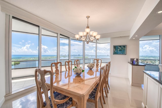 dining space with a chandelier, a water view, and a healthy amount of sunlight