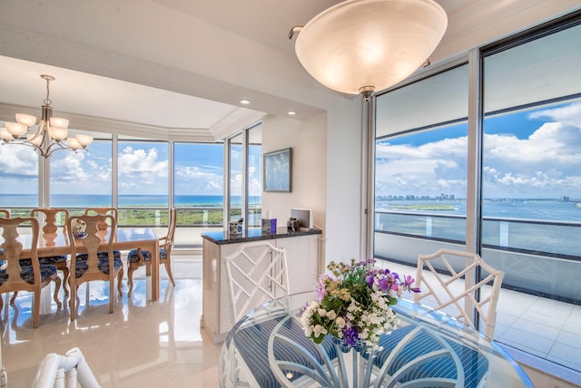 tiled dining area with a water view and an inviting chandelier