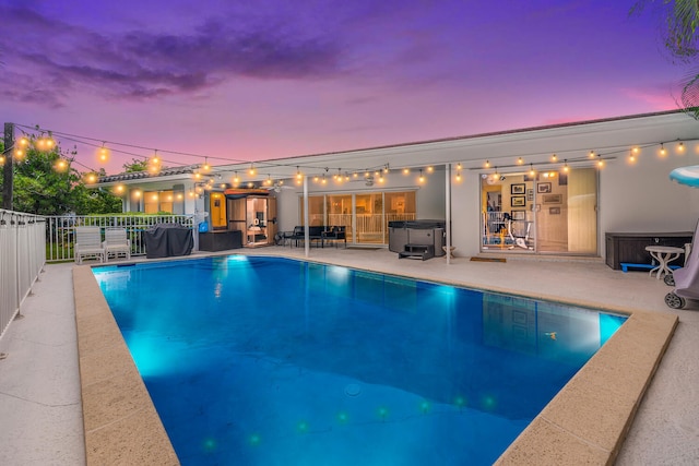 pool at dusk with a patio