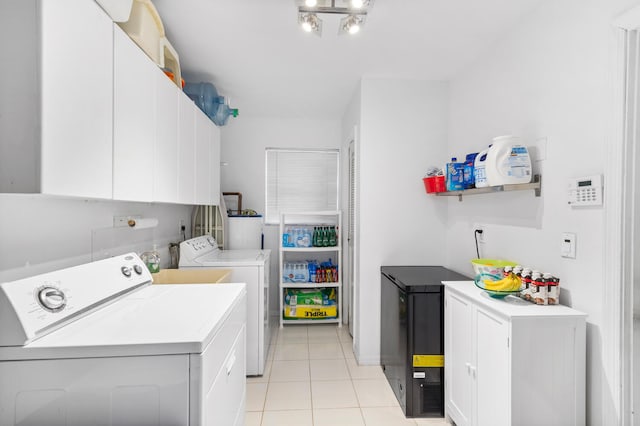 laundry room with cabinets, light tile patterned floors, and washer and clothes dryer