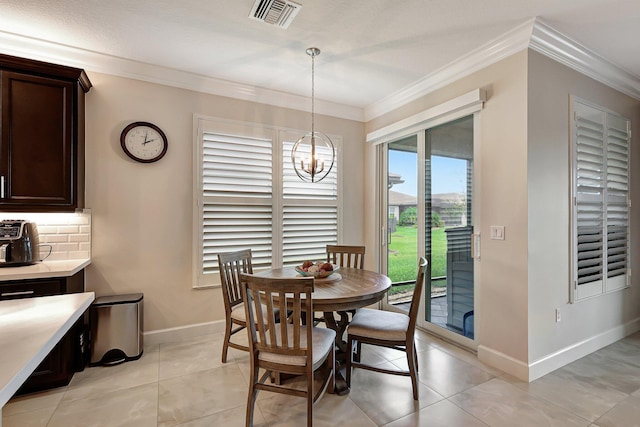 tiled dining area featuring crown molding and a chandelier