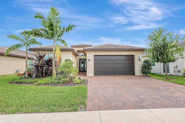 view of front of property with a garage and a front lawn