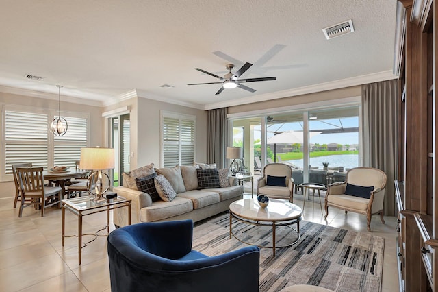 tiled living room featuring a textured ceiling, ceiling fan with notable chandelier, ornamental molding, and a water view