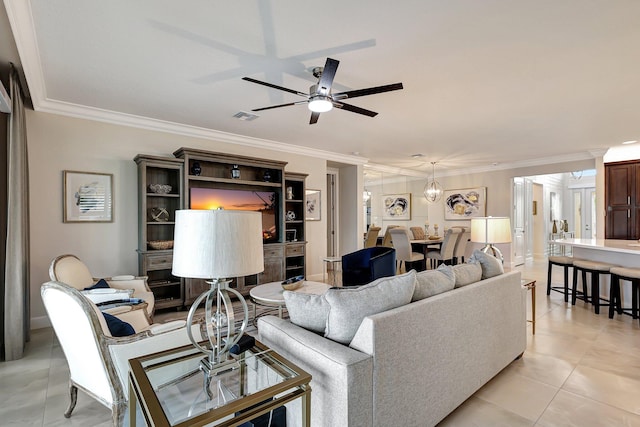 tiled living room with ornamental molding and ceiling fan