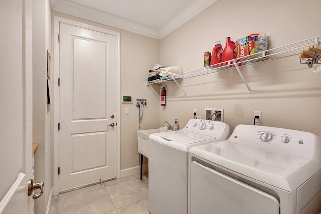 washroom with washing machine and dryer, ornamental molding, and sink