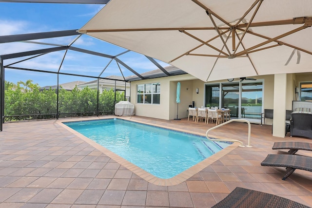 view of swimming pool featuring glass enclosure and a patio area