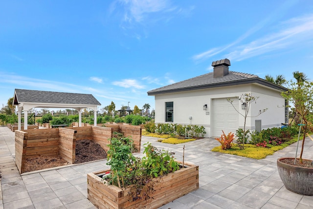 view of patio / terrace featuring a gazebo and a garage