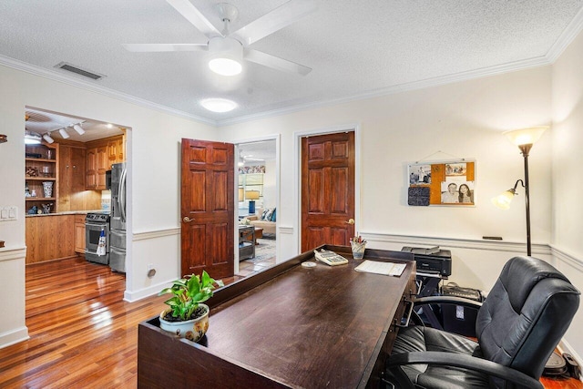 home office with hardwood / wood-style floors, ceiling fan, crown molding, and a textured ceiling