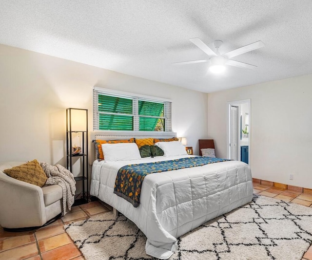 tiled bedroom with ceiling fan and a textured ceiling