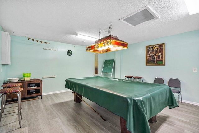 recreation room featuring wood-type flooring, a textured ceiling, and pool table