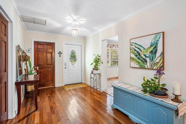 entryway featuring a textured ceiling, hardwood / wood-style flooring, and crown molding