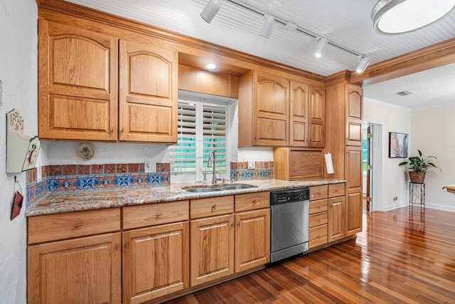 kitchen with dark wood-type flooring, track lighting, sink, stainless steel dishwasher, and light stone countertops