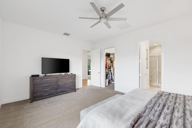 carpeted bedroom featuring ensuite bath, ceiling fan, a spacious closet, and a closet