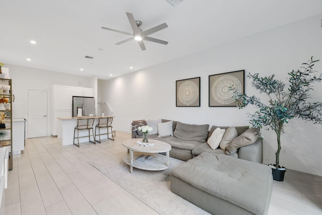 living room featuring ceiling fan and light wood-type flooring