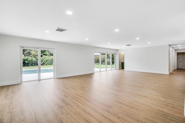 spare room with light hardwood / wood-style floors and a wealth of natural light