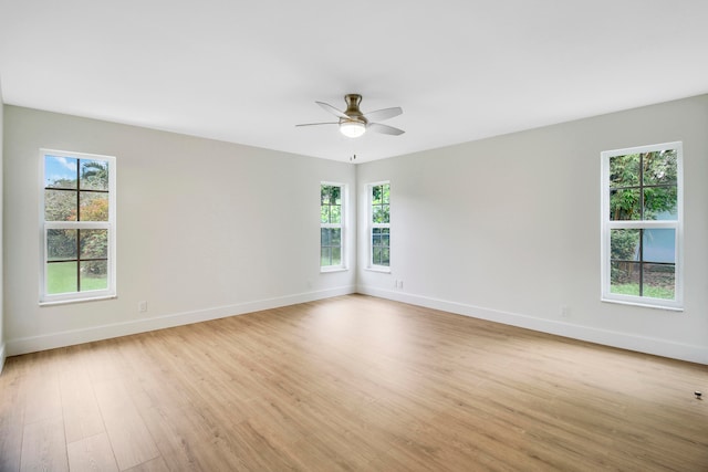 spare room featuring ceiling fan, light hardwood / wood-style floors, and a wealth of natural light