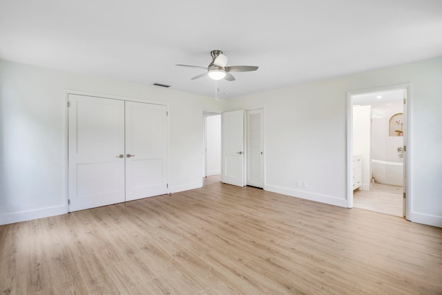 unfurnished bedroom featuring ceiling fan, ensuite bath, and light hardwood / wood-style floors