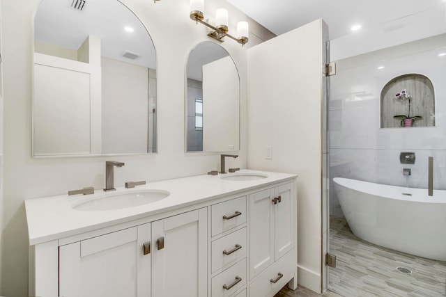 bathroom with separate shower and tub, hardwood / wood-style flooring, and vanity