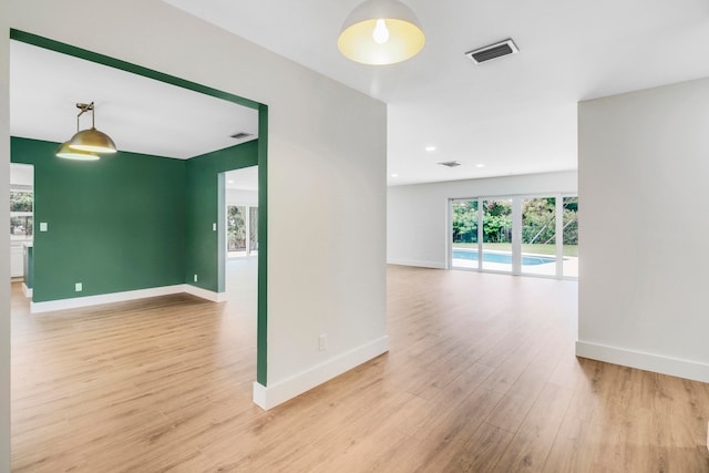 empty room with light hardwood / wood-style floors and a wealth of natural light