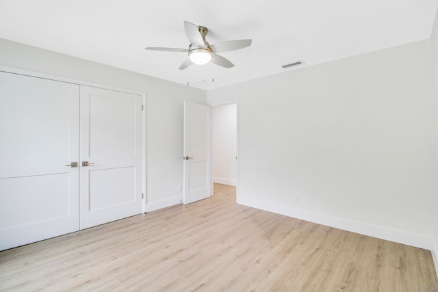 unfurnished bedroom featuring light wood-type flooring, ceiling fan, and a closet