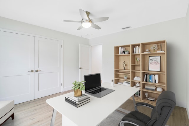 home office with ceiling fan and light hardwood / wood-style floors