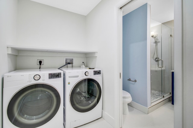 clothes washing area with washer and dryer and light tile patterned floors