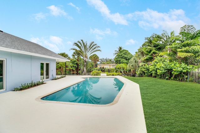 view of pool featuring a patio and a yard