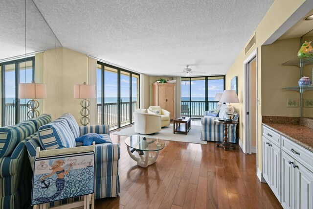 living room with a water view, floor to ceiling windows, and plenty of natural light