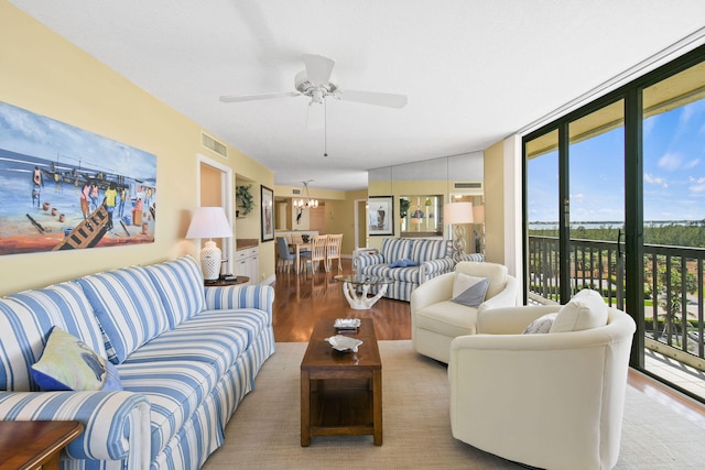 living room with wood-type flooring, lofted ceiling, ceiling fan, and a healthy amount of sunlight