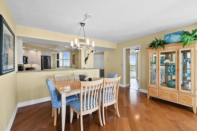 dining room featuring a textured ceiling, ceiling fan with notable chandelier, and hardwood / wood-style floors