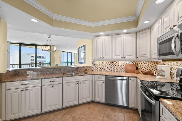 kitchen with white cabinets, a notable chandelier, appliances with stainless steel finishes, and crown molding