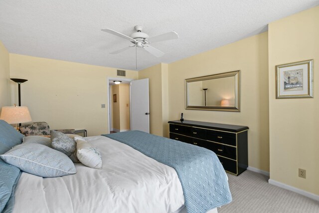 carpeted bedroom with a textured ceiling and ceiling fan