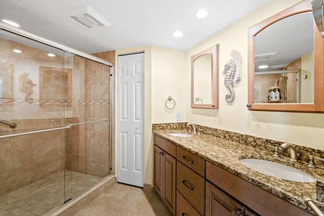 bathroom with tile patterned flooring, vanity, and a shower with door