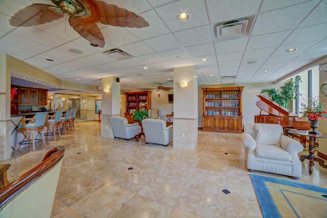 living room featuring a paneled ceiling and ceiling fan