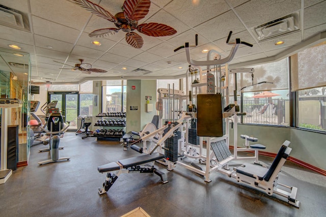 workout area featuring a wall of windows, a paneled ceiling, and ceiling fan