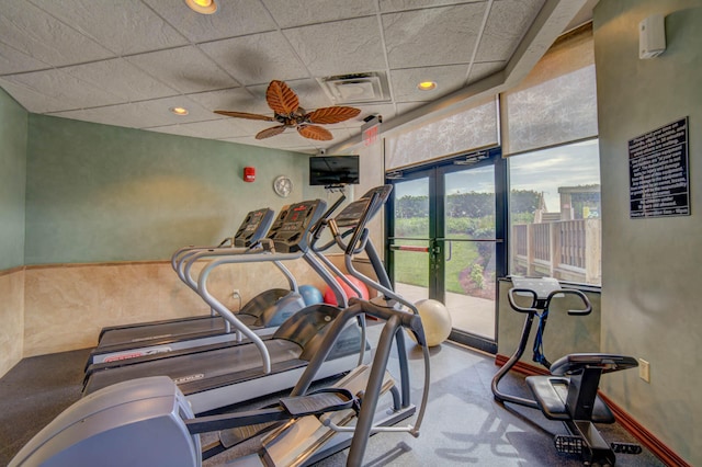 gym featuring a drop ceiling and ceiling fan