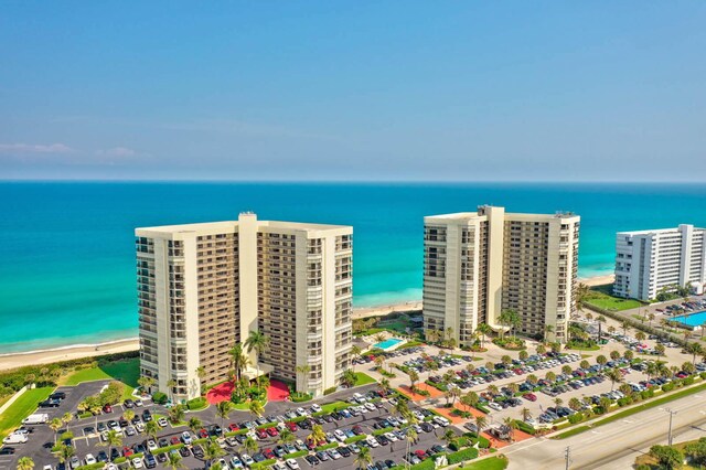 drone / aerial view featuring a water view and a beach view