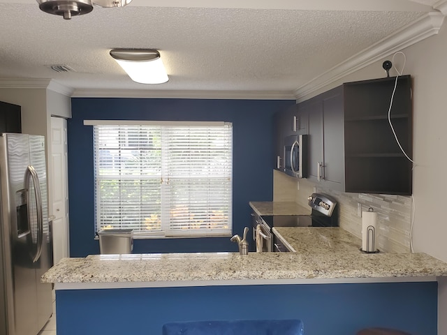 kitchen featuring ornamental molding, a textured ceiling, appliances with stainless steel finishes, and kitchen peninsula