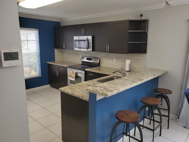 kitchen featuring stainless steel appliances, kitchen peninsula, sink, and a kitchen breakfast bar