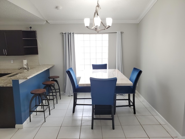 tiled dining area with ornamental molding, a notable chandelier, a textured ceiling, and sink