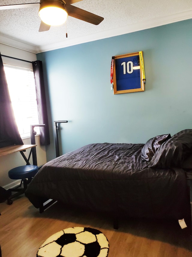 bedroom featuring ceiling fan, hardwood / wood-style flooring, crown molding, and a textured ceiling