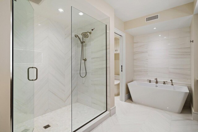 bathroom with tile patterned flooring, toilet, and independent shower and bath